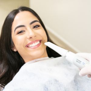 Intraoral scanner positioned near a patient's mouth for accurate dental imaging and diagnostics.