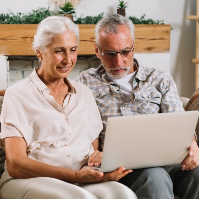 Old couple searching for hospitals on laptop