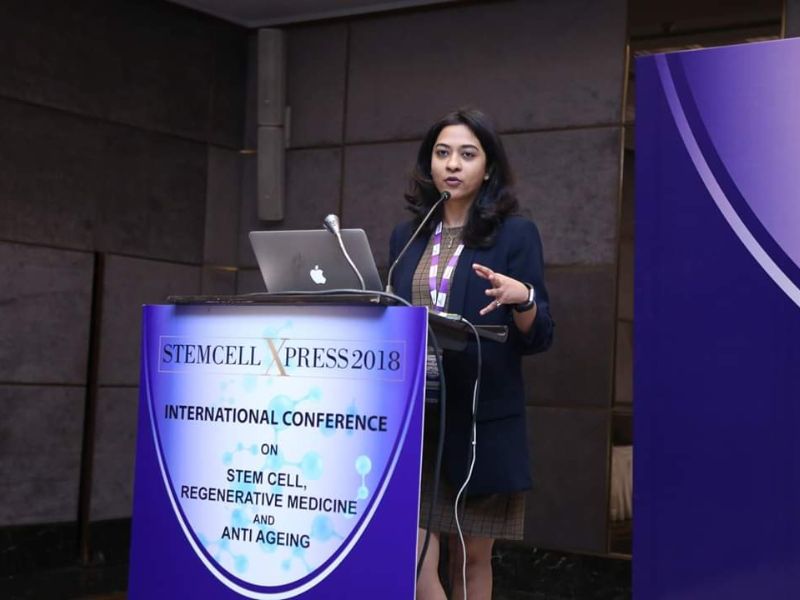 a female indian dentist speaking at a conference