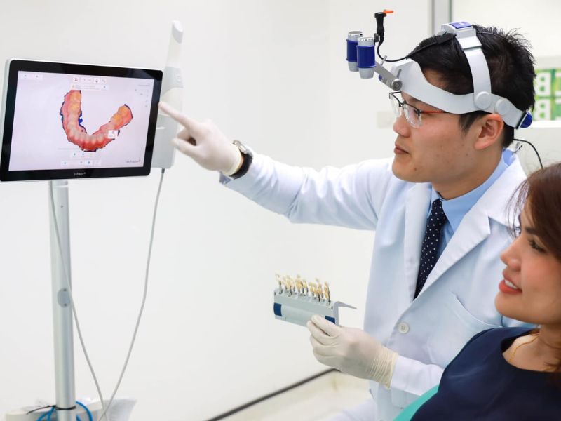 Dentist displaying color shade options for veneers on a digital screen to a patient