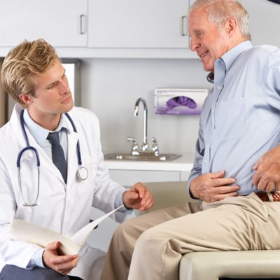 Elderly patient explaining hip-related symptoms to a healthcare professional