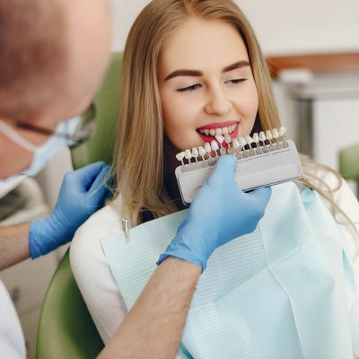 dentist choosing teeth shade of a white girl